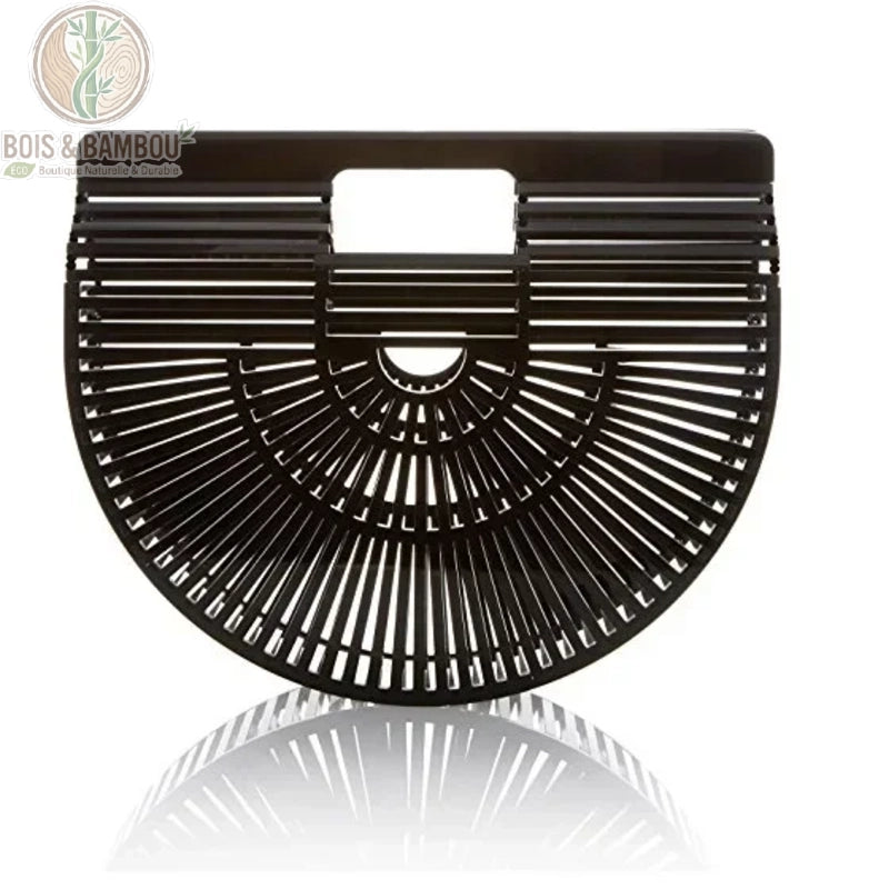Sac panier en bambou tresse noir 1. Vue de face d'un sac à main demi-lune en bambou noir intense avec finition brillante, présentant un design ajouré géométrique sur un fond blanc avec reflet.