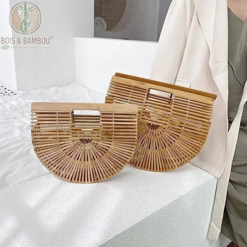 Sac panier en bambou tresse situation 1. Deux sacs à main demi-lune en bambou naturel de tailles différentes, petit et grand, posés côte à côte sur un support blanc épuré.