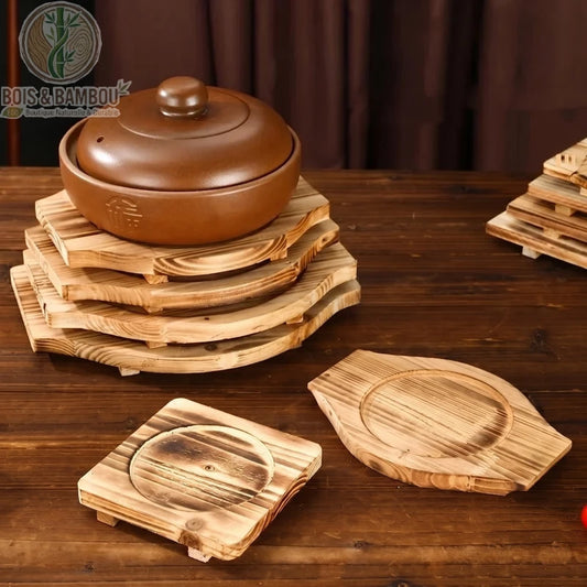 Socle en Bois pour Bol Coréen. Plusieurs socles artisanaux en bois brûlé empilés et disposés sur une table, dont un supportant un bol traditionnel avec couvercle. Style rustique.