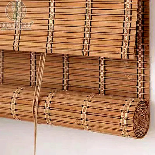 Store enrouleur en bambou naturel au design robuste, composé de lattes plates reliées par un tissage discret. Son système d'enroulement à cordon permet de moduler la lumière tout en apportant une texture authentique et boisée à votre décoration intérieure.