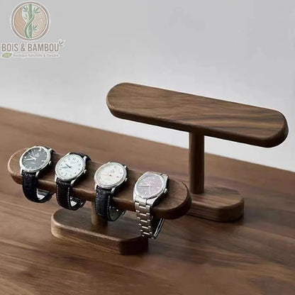 Support de montre en noyer présentant quatre montres de luxe sur un socle élégant en bois sombre.