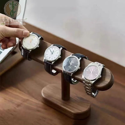 support montre bois noyer massif en situation main qui pose montre 4 bracelets accrochés