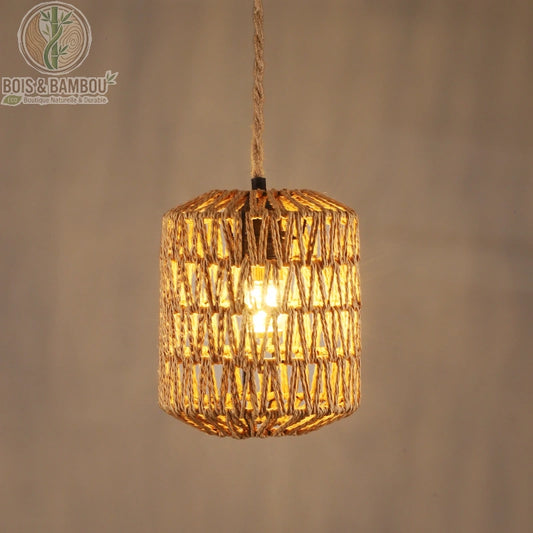 Suspension en rotin naturel tressé , un luminaire cylindrique artisanal avec un tressage ajouré laissant passer une lumière tamisée, suspendu par une corde en jute assortie.