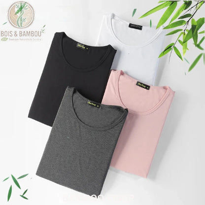 T-shirt en fibre de bambou ultra-respirant. Quatre t-shirts pliés aux couleurs sobres (noir, blanc, gris chiné et rose pâle) disposés sur un fond blanc décoré de feuilles de bambou.