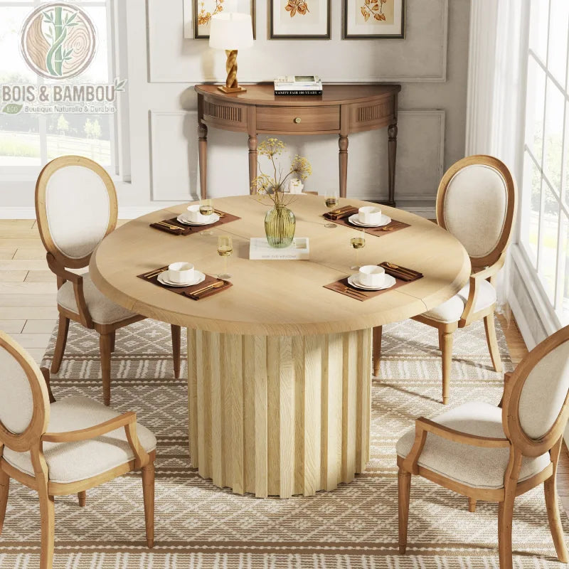 Table a manger en bois massif ovale 6 personnes naturelle. Table ronde en bois clair avec un pied central à lattes, entourée de chaises de style médaillon dans une salle à manger élégante.