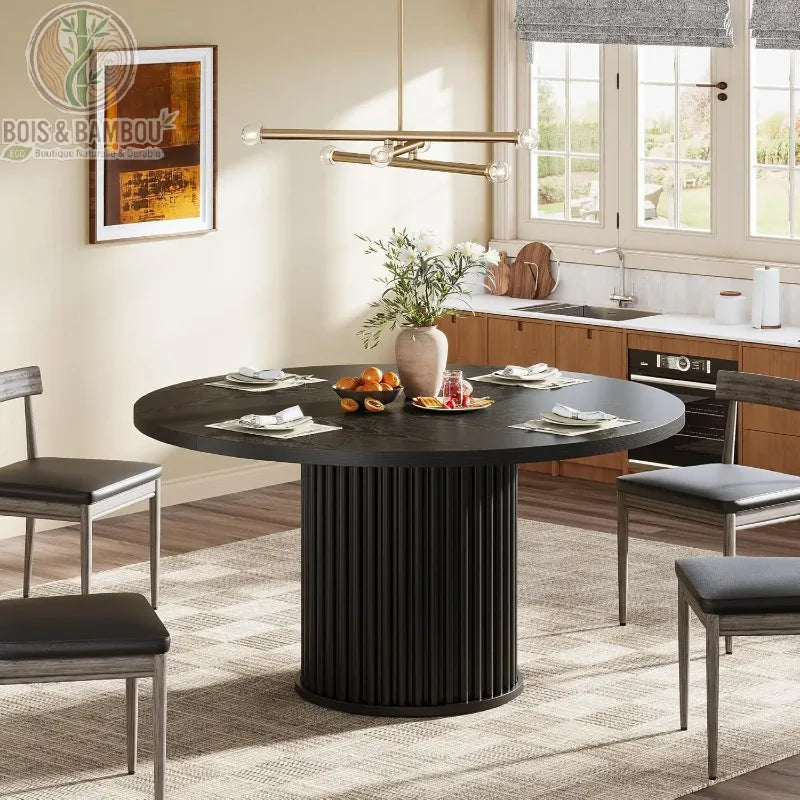Table a manger en bois massif ovale 6 personnes noir. Table de salle à manger noire au design contemporain avec pied central cannelé, dressée pour six personnes dans une cuisine ouverte moderne.
