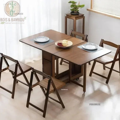 Table a manger pliante en bambou. Une élégante table modulable aux tons foncés dressée pour deux personnes, accompagnée de quatre chaises pliantes assorties dans une salle à manger lumineuse.