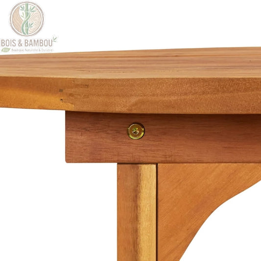 Table bois massif a Manger en Acacia details. Gros plan sur l'assemblage de qualité d'une table en acacia, montrant la quincaillerie dorée reliant le pied robuste au tablier en bois.