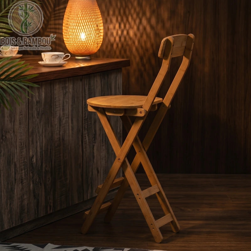 Tabouret de Bar en Bambou situation 3. Tabouret pliant en bambou placé devant un comptoir en bois sombre, éclairé par une lampe d'ambiance chaleureuse pour une atmosphère cosy et naturelle.