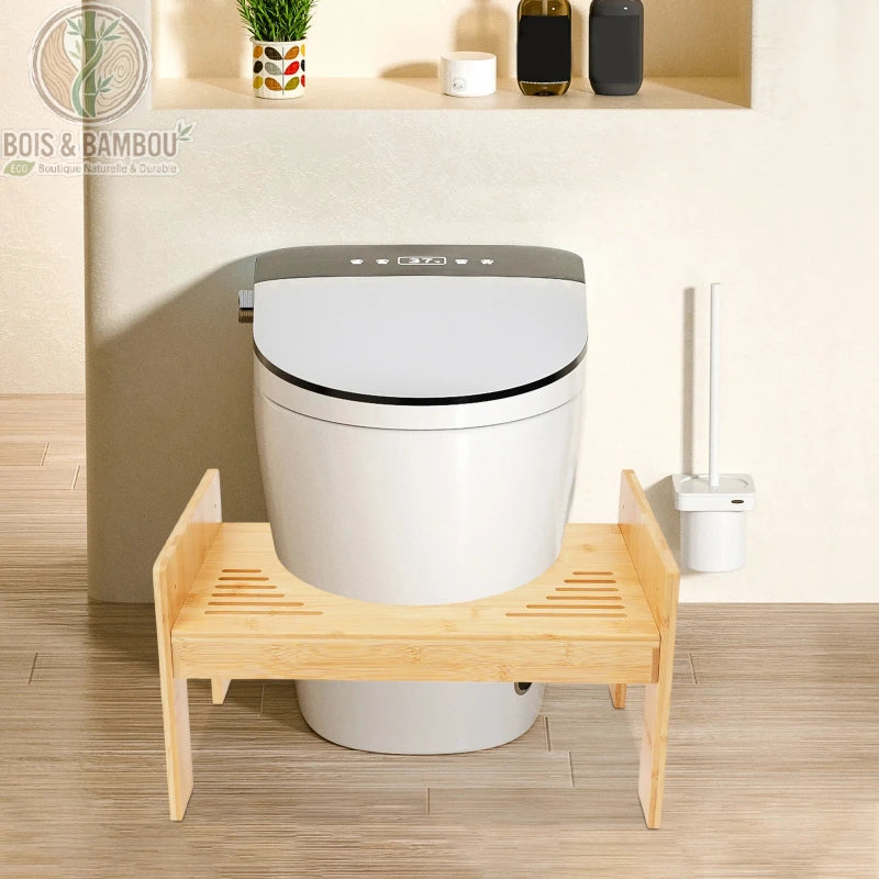 Tabouret de toilette en bambou. Un marchepied ergonomique en bambou naturel avec des rainures antidérapantes, positionné au pied d'un WC moderne pour améliorer la posture physiologique.