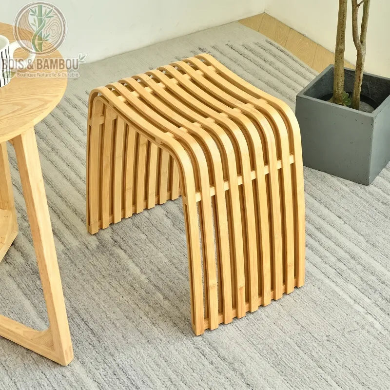 Tabouret moderne en bambou Nan classique au design incurvé à lattes, posé sur un tapis gris.