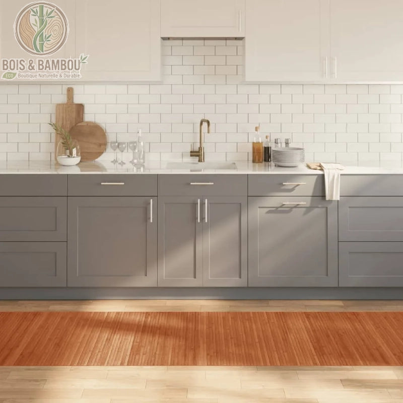 Tapis en bambou marron au fini lustré, composé de fines lattes de bois alignées pour créer une surface lisse et uniforme. Présenté dans une cuisine moderne aux tons gris et blanc, ce long tapis rectangulaire apporte une chaleur organique et une texture naturelle au sol.