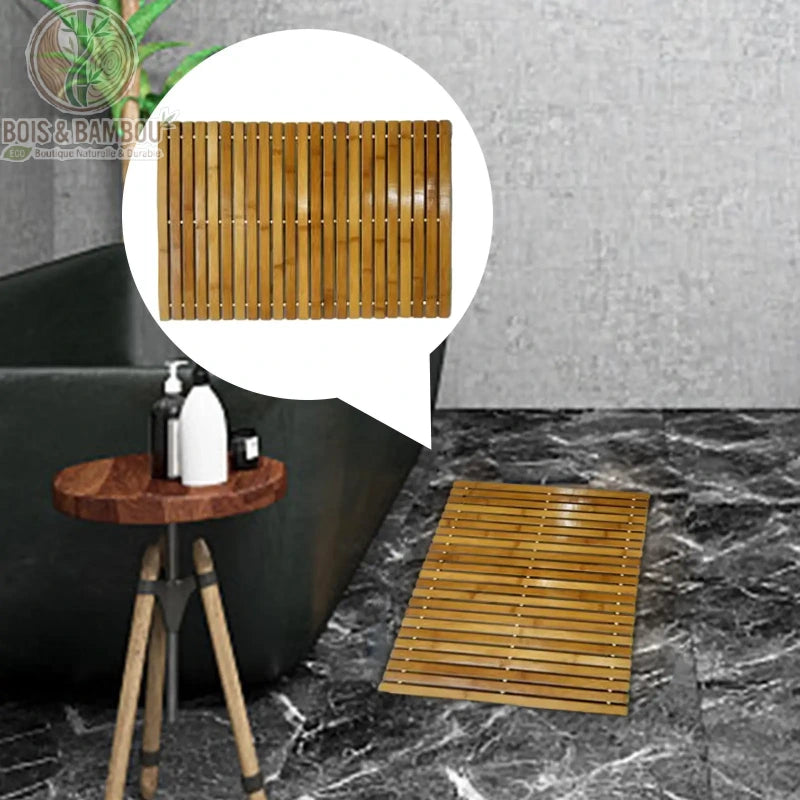 Tapis bambou naturel posé devant une baignoire noire en salle de bain moderne