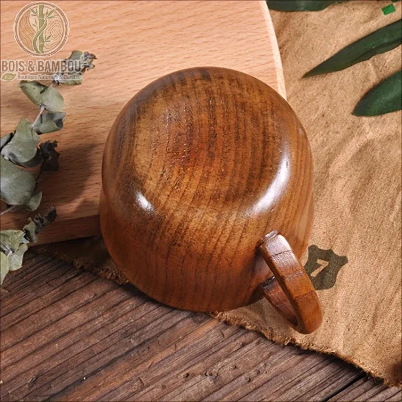 Tasse en bois naturel vintage vue trois quarts posée sur planche bois rustique