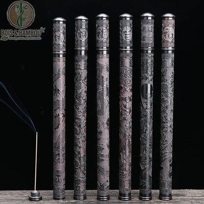 Tube d'Encens en Ébène Noir, un ensemble de six étuis à encens en bois sombre sculpté, présentant des motifs traditionnels de dragons et des sinogrammes sur un fond noir, accompagné d'un bâtonnet d'encens allumé.