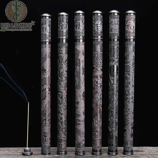 Tube d'Encens en Ébène Noir, un ensemble de six étuis à encens en bois sombre sculpté, présentant des motifs traditionnels de dragons et des sinogrammes sur un fond noir, accompagné d'un bâtonnet d'encens allumé.