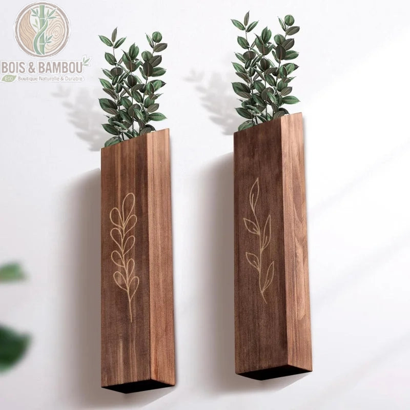 Deux vases muraux en bois gravés avec feuillage vert, vue rapprochée motifs botaniques sur bois marron