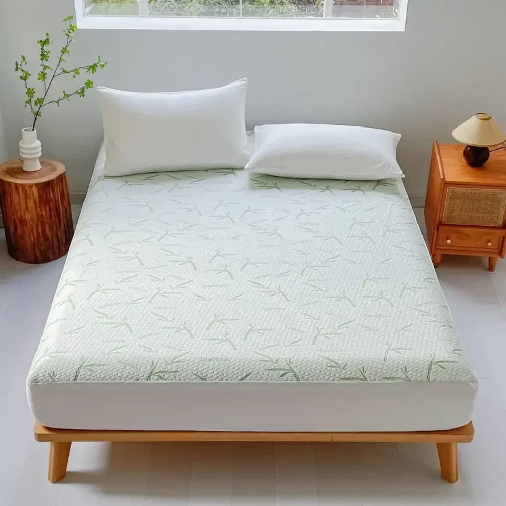 Alèse en bambou imperméable à feuilles vertes sur un lit en bois