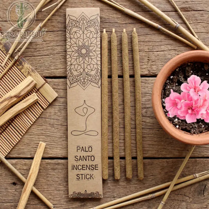 Bâtons d'encens Palo Santo aux fleurs fraîches dans leur coffret kraft, avec un pot de fleurs roses sur fond bois