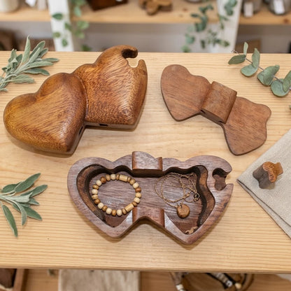 Boîte à bijoux en bois sculpté cœurs jumeaux, ouverte avec bracelet et collier en perles de bois à l'intérieur