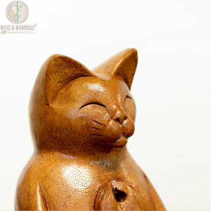 Gros plan sur le visage sculpté à la main d'un porte-encens chat de yoga en bois