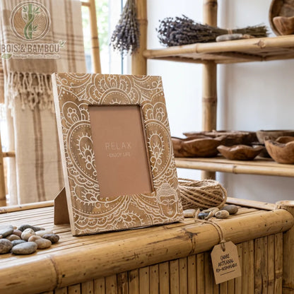 Cadre photo Bouddha bois de manguier gravé blanc 23 cm par 28 cm, posé dans une boutique, texte Relax Enjoy Life