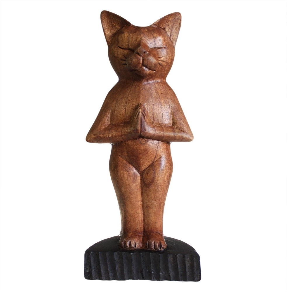 Chat en bois sculpté marron, posture yoga debout mains jointes, fond blanc, vue de face.