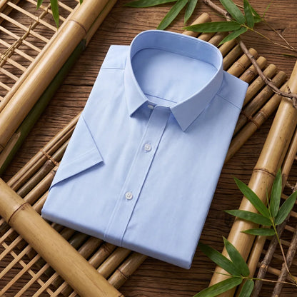 Chemise homme en fibre de bambou manches courtes bleu clair, pliée sur fond bambou naturel