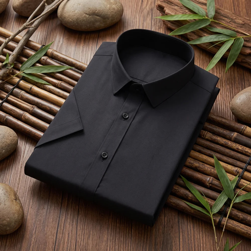 Chemise homme en fibre de bambou manches courtes noire, pliée sur fond bambou naturel