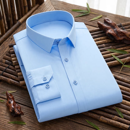 Chemise homme en fibre de bambou unie bleu ciel, pliée sur une table en bois près d'une fenêtre