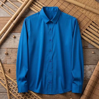 Chemise homme en fibre de bambou unie bleu canard, posée à plat sur une natte de bambou tressé