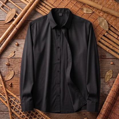 Chemise homme en fibre de bambou unie noire, posée à plat sur bois et bambou tressé
