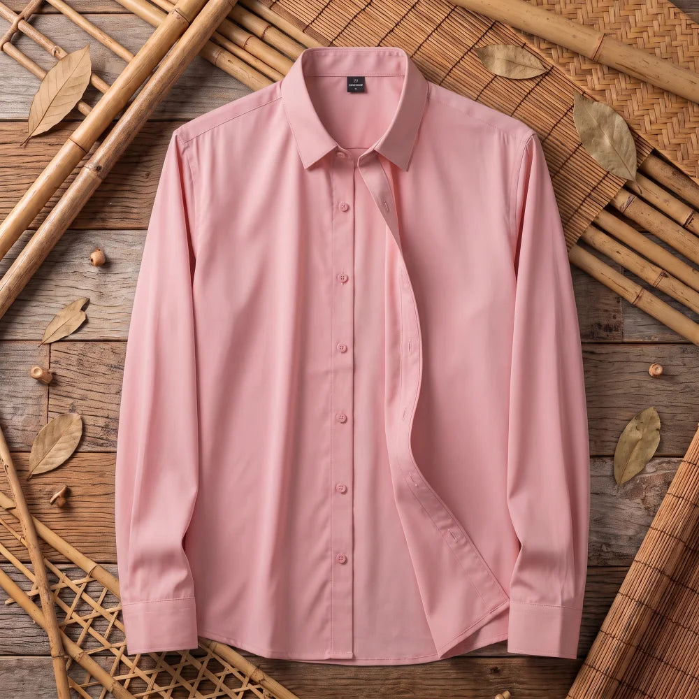 Chemise homme en fibre de bambou unie rose pâle, posée à plat sur bois et bambou tressé