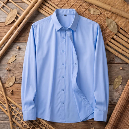 Chemise homme en fibre de bambou unie bleu ciel, posée à plat sur bois et bambou tressé