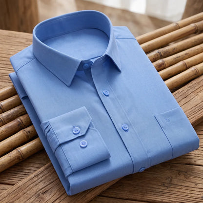 Chemise homme en fibre de bambou coloris bleu uni, pliée sur une natte de bambou