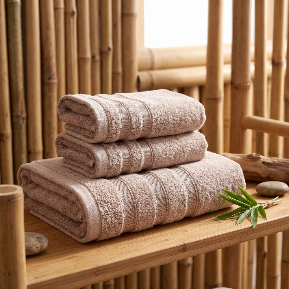 Coffret de 3 serviettes en bambou coloris camel, pliées et empilées sur une étagère en bois, décor bambou