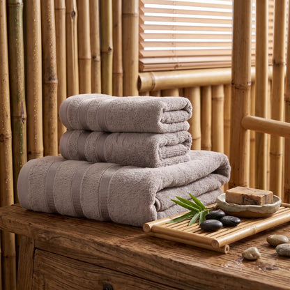 Coffret de 3 serviettes en bambou coloris gris, pliées et empilées dans une salle de bain en bois et bambou