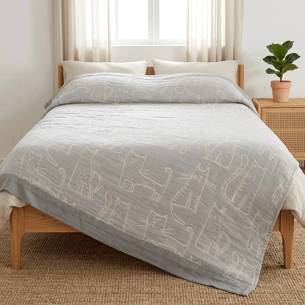 Couverture gaze coton bambou motif chat sur un lit, coloris gris