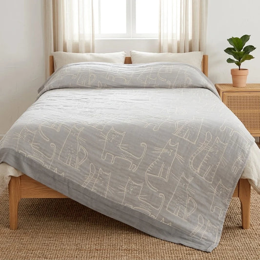 Couverture gaze coton bambou motif chat sur un lit, coloris gris
