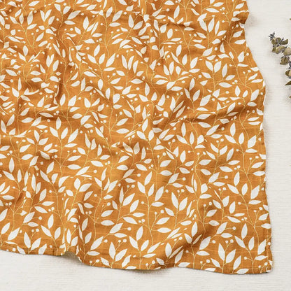 Couverture légère bébé en coton et bambou, motif feuillage blanc sur fond jaune moutarde