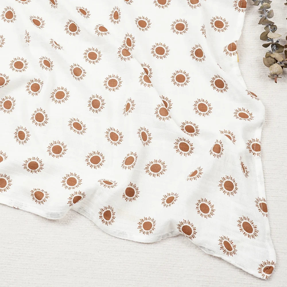 Couverture légère bébé en coton et bambou, motif soleils orange sur fond blanc