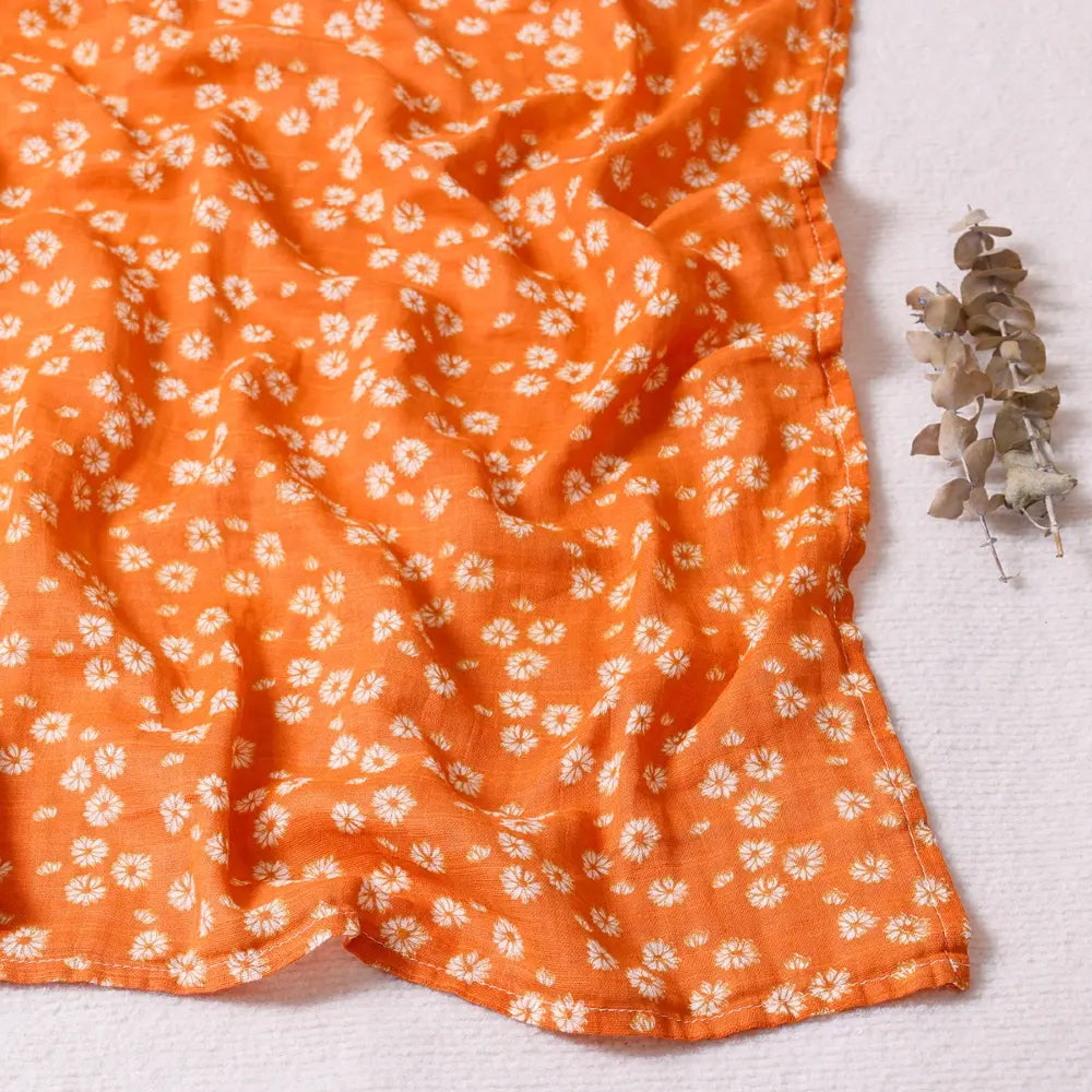 Couverture légère bébé en coton et bambou, motif petites marguerites blanches sur fond orange