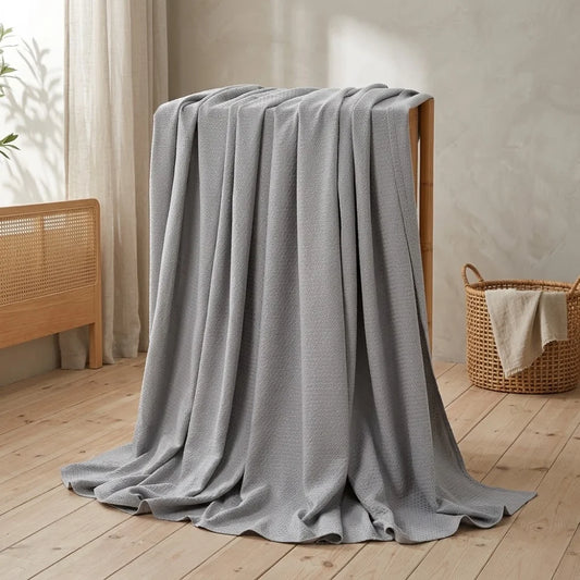 Couverture rafraîchissante en coton bambou gris, gros plan sur le tissage texturé et léger