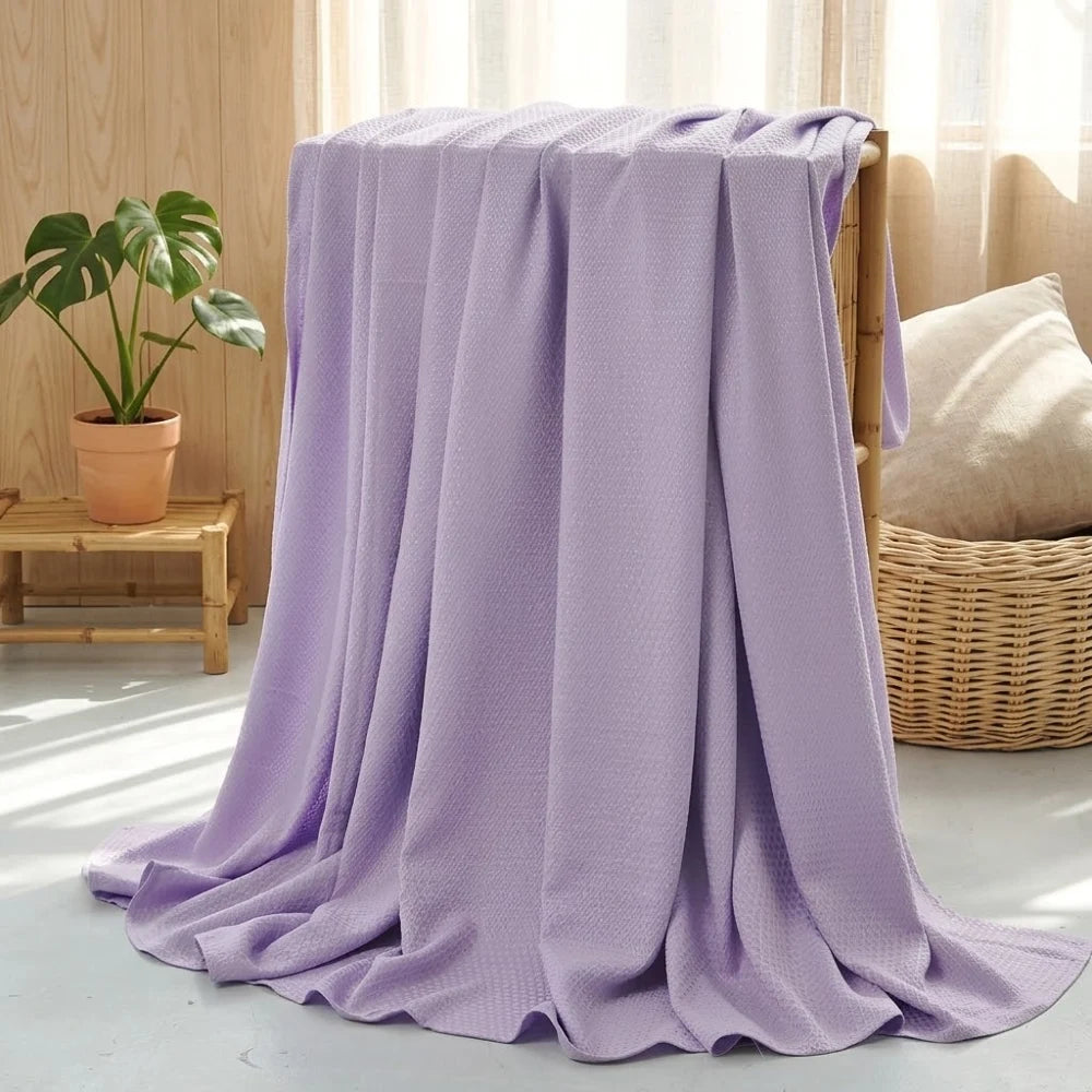 Couverture rafraîchissante en coton bambou mauve, gros plan sur la texture douce et drapée