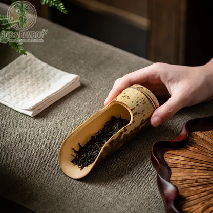Cuillere a the bambou naturel mouchete tenu en main feuilles the noir plateau rotin fonce - Bois et Bambou Eco
