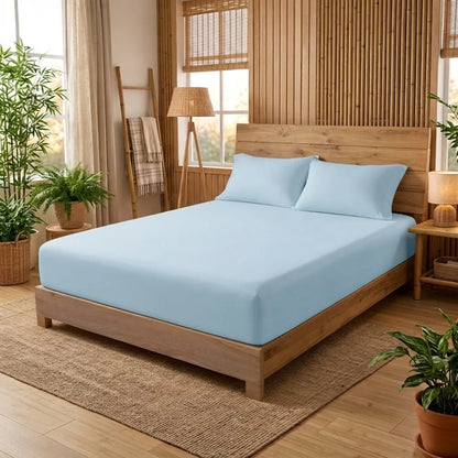 Drap-housse en bambou bleu pastel avec 2 taies sur un lit