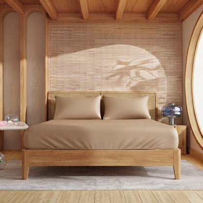Drap-housse en bambou caramel sur un lit en bois avec deux taies assorties