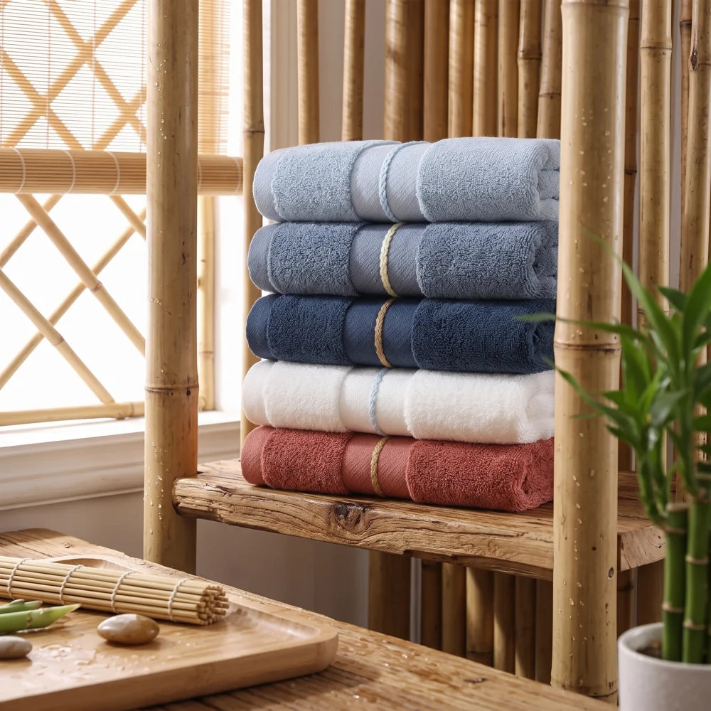 Ensemble de serviettes en bambou haut de gamme, plusieurs coloris, empilées dans une salle de bain en bois et bambou