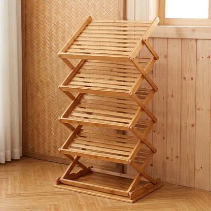 Étagère à chaussures pliable en bambou, structure en X à niveaux inclinés, posée contre un mur