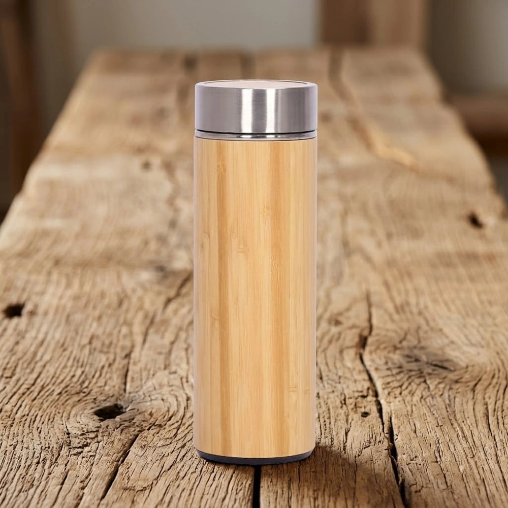 Gourde en bambou isotherme compacte, format 450 ml, coque en bambou naturel et couvercle inox, sur bois brut